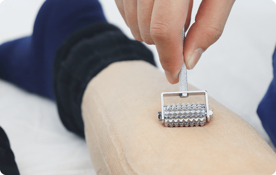 手に持ったローラー状の器具で、ふくらはぎをやさしく刺激している様子