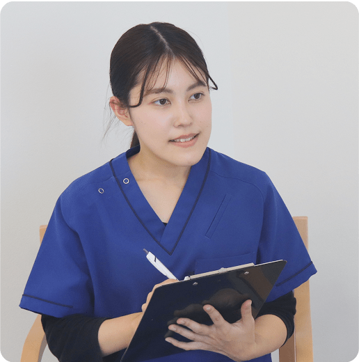 青い制服を着た女性スタッフが、ペンとタブレットを持って話をしている様子